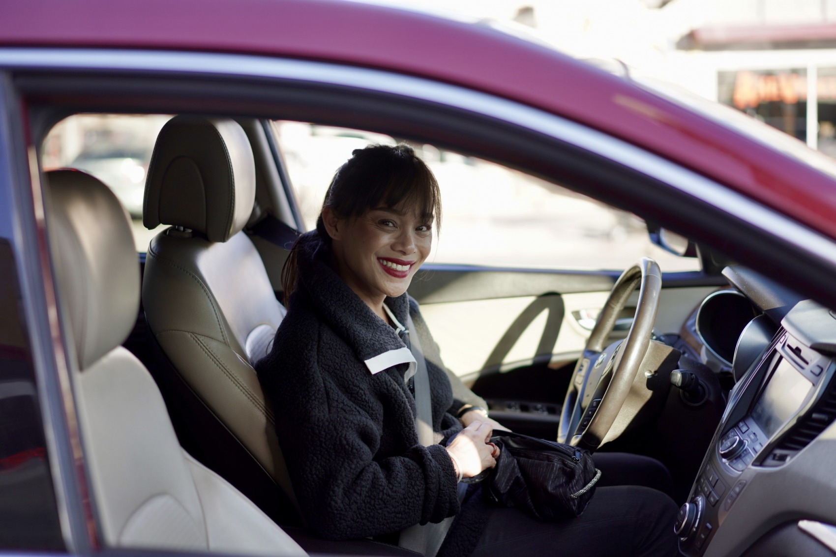 girl smiling in her car. 